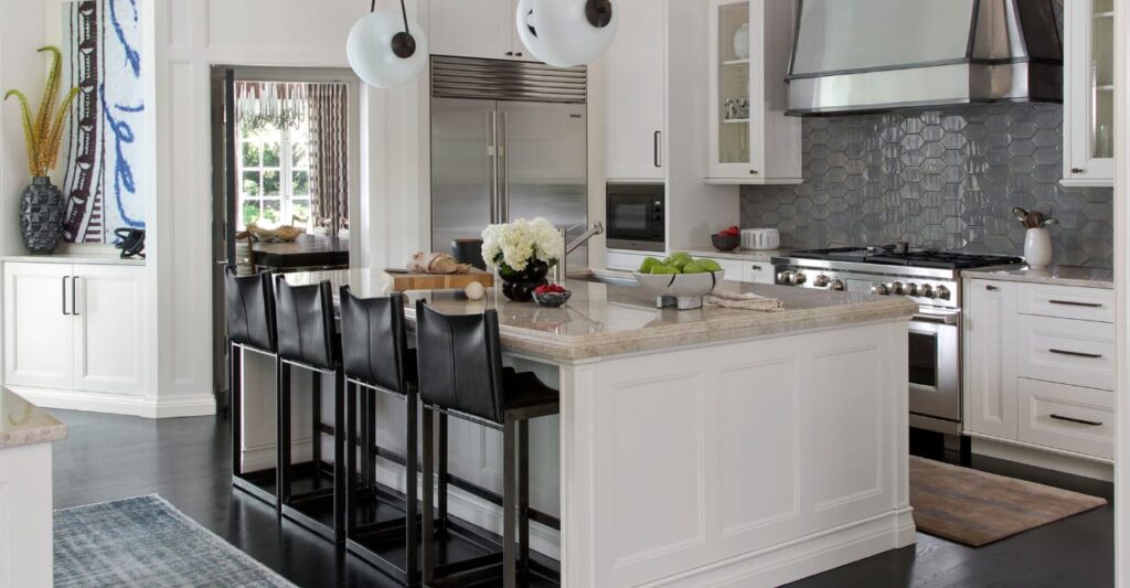 Spacious luxury villa interior featuring marble floors, a gold crystal chandelier, rose-gold dining set, exposed wooden ceiling beams, and a staircase with metal railings.