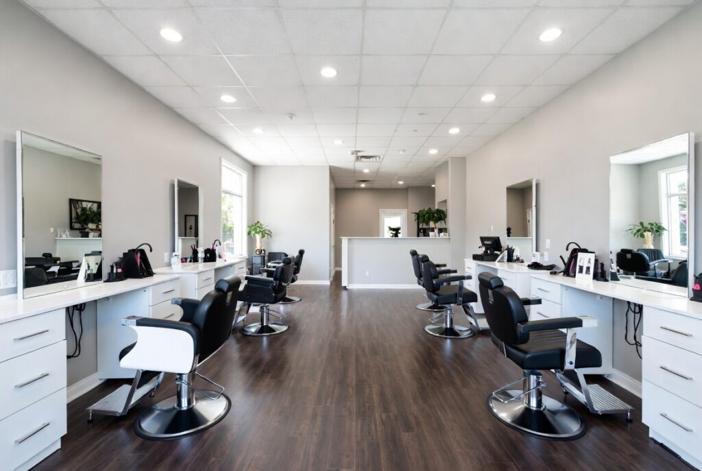 Modern hair salon interior with black styling chairs and white vanities