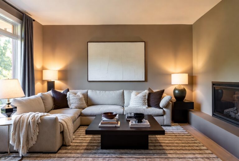 Warm staged living room with sectional sofa, fireplace, and abstract wall art in a real estate listing